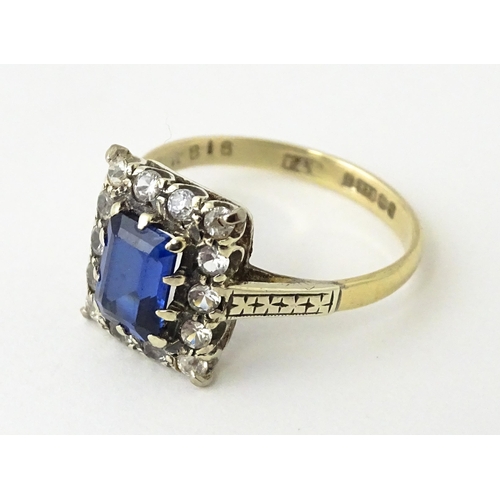 612 - A 9ct gold ring set with central sapphire bordered by white stones.  Ring size approx. M