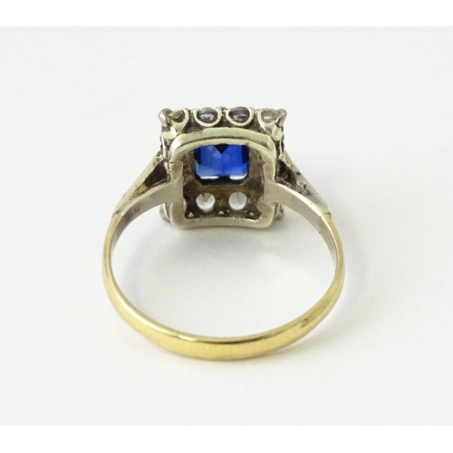 612 - A 9ct gold ring set with central sapphire bordered by white stones.  Ring size approx. M