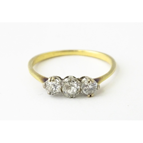 613 - A gold ring set with a trio of diamonds.  Ring size approx. O