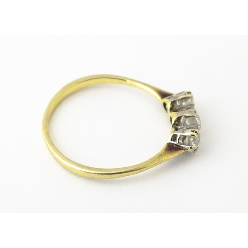 613 - A gold ring set with a trio of diamonds.  Ring size approx. O