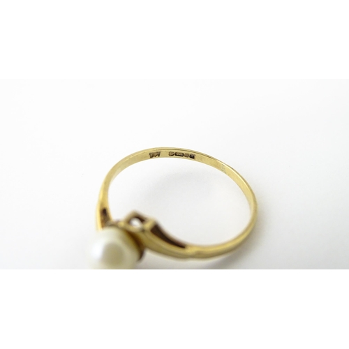 614 - A 9ct gold ring set with central pearl. Ring size approx. S 1/2