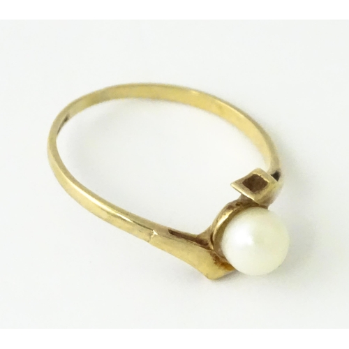 614 - A 9ct gold ring set with central pearl. Ring size approx. S 1/2