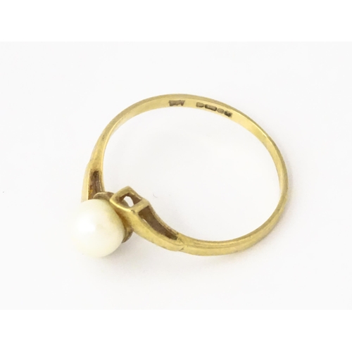 614 - A 9ct gold ring set with central pearl. Ring size approx. S 1/2