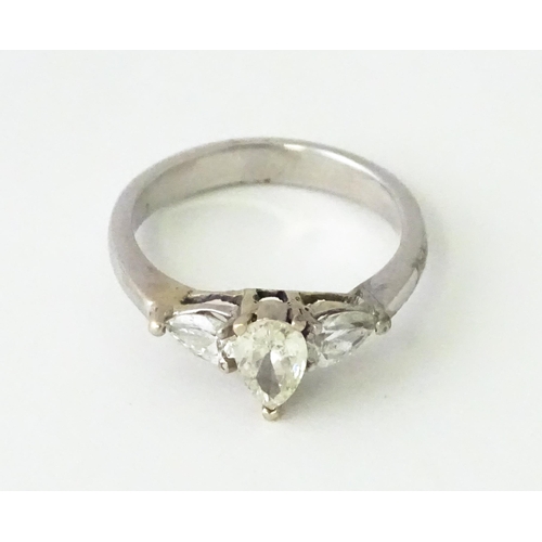 615 - A white gold ring set with central diamonds flanked by diamonds. Ring size approx. J