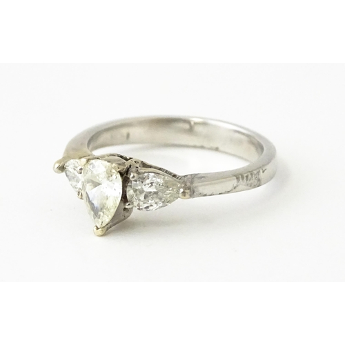 615 - A white gold ring set with central diamonds flanked by diamonds. Ring size approx. J