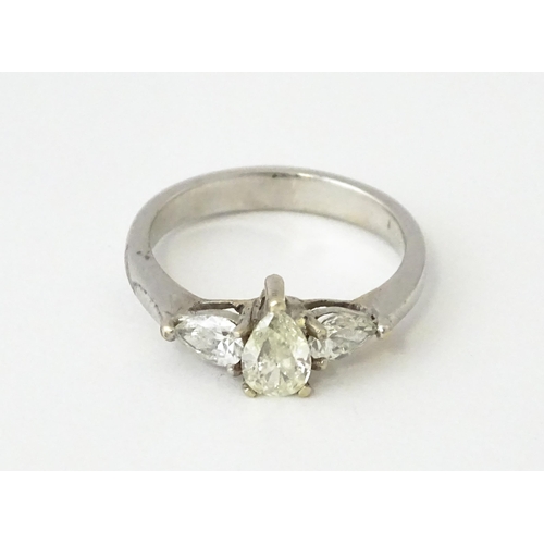 615 - A white gold ring set with central diamonds flanked by diamonds. Ring size approx. J