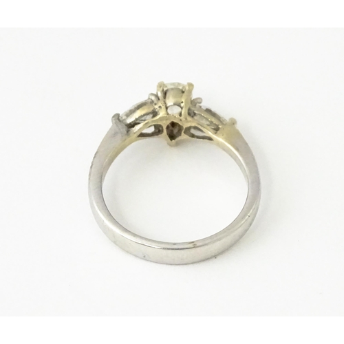 615 - A white gold ring set with central diamonds flanked by diamonds. Ring size approx. J