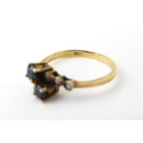 616 - A 9ct gold ring set with two blue stones flanked by three diamonds to each shoulder. Ring size appro... 