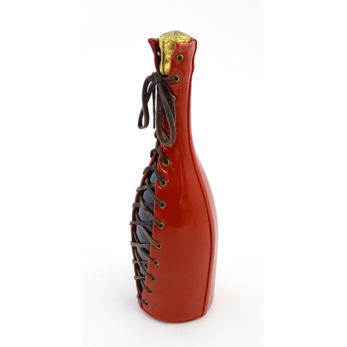 1123 - A 1999 limited edition 75cl bottle of Piper-Heidsieck champagne in a Jean-Paul Gaultier red PVC cors... 