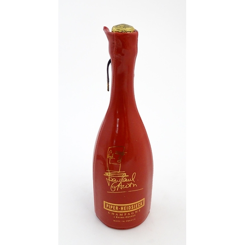 1123 - A 1999 limited edition 75cl bottle of Piper-Heidsieck champagne in a Jean-Paul Gaultier red PVC cors... 