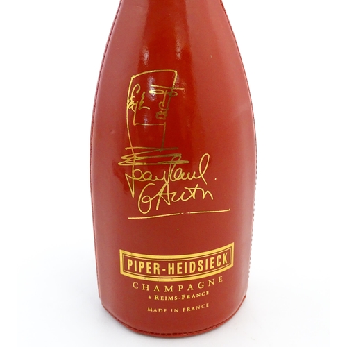 1123 - A 1999 limited edition 75cl bottle of Piper-Heidsieck champagne in a Jean-Paul Gaultier red PVC cors... 