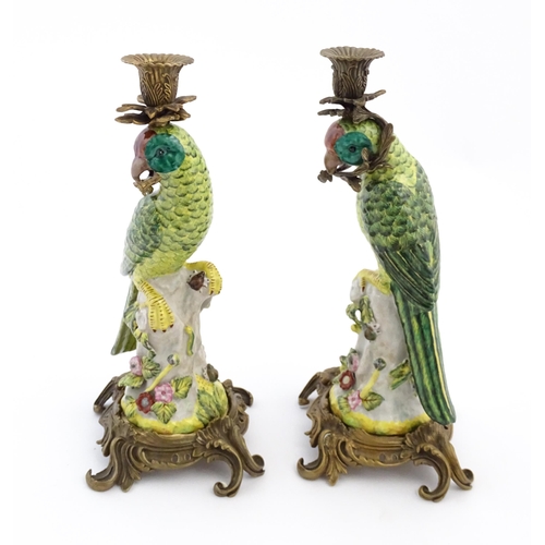 1255 - A pair of late 20thC ceramic candlesticks, the stem formed as a parrot perched on a branch with flow... 