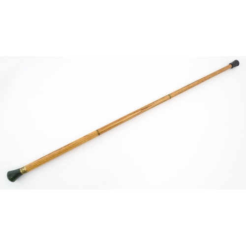 1276 - An Oriental walking stick / cane with jade coloured hardstone pommel. Approx. 38 1/4