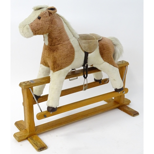 870 - Toy: A Mulholland & Bailie brown and white plush rocking horse on a wooden trestle base. Bears label... 