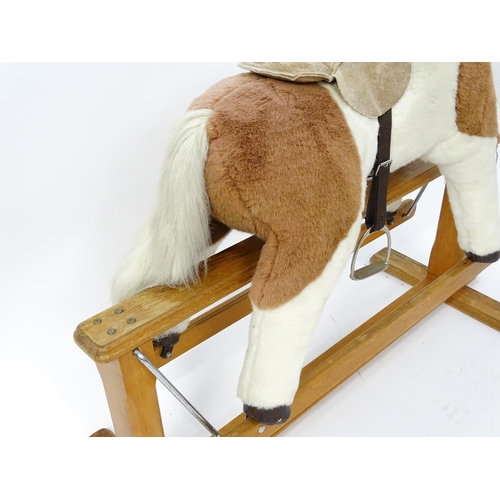 870 - Toy: A Mulholland & Bailie brown and white plush rocking horse on a wooden trestle base. Bears label... 