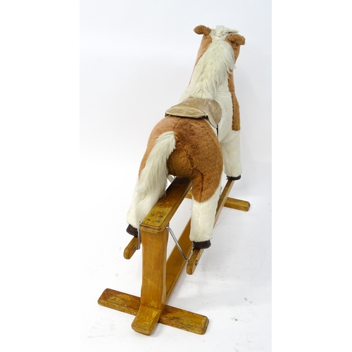 870 - Toy: A Mulholland & Bailie brown and white plush rocking horse on a wooden trestle base. Bears label... 