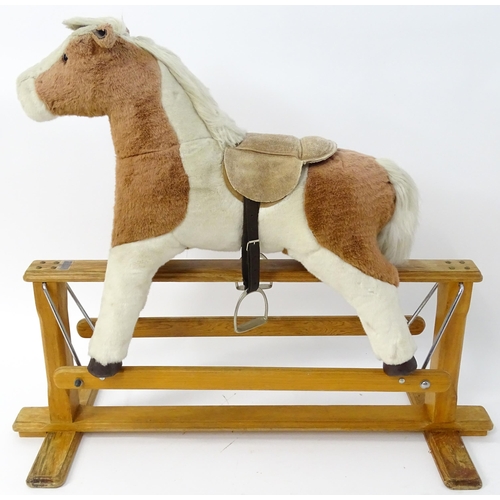 870 - Toy: A Mulholland & Bailie brown and white plush rocking horse on a wooden trestle base. Bears label... 