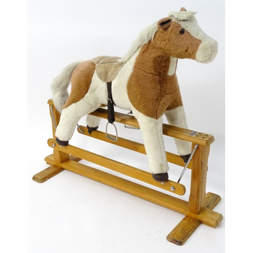 870 - Toy: A Mulholland & Bailie brown and white plush rocking horse on a wooden trestle base. Bears label... 