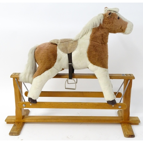 870 - Toy: A Mulholland & Bailie brown and white plush rocking horse on a wooden trestle base. Bears label... 