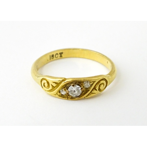 619 - An 18ct gold ring set with three diamonds. Ring size approx. I 1/2