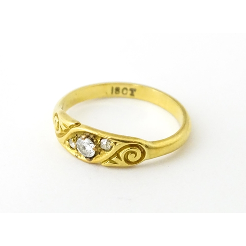 619 - An 18ct gold ring set with three diamonds. Ring size approx. I 1/2