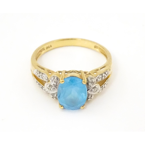 620 - A 9ct gold ring set with topaz flanked by diamonds. Ring size approx. O 1/2