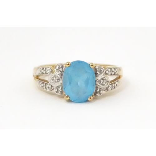 620 - A 9ct gold ring set with topaz flanked by diamonds. Ring size approx. O 1/2