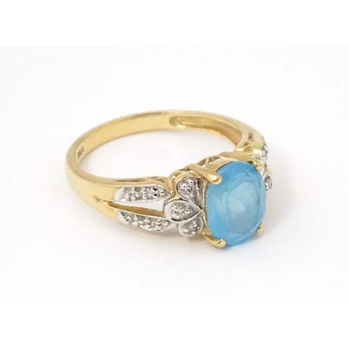 620 - A 9ct gold ring set with topaz flanked by diamonds. Ring size approx. O 1/2