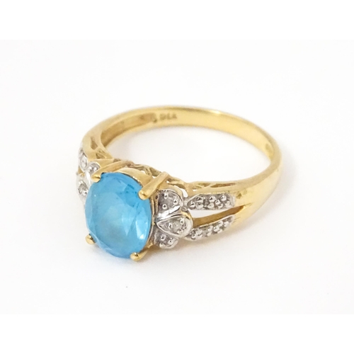 620 - A 9ct gold ring set with topaz flanked by diamonds. Ring size approx. O 1/2