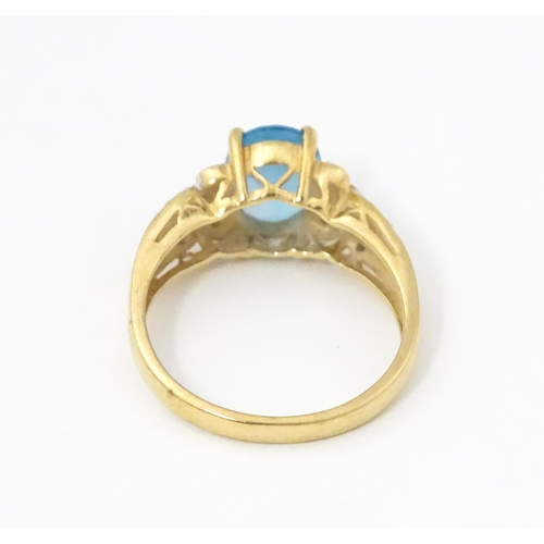 620 - A 9ct gold ring set with topaz flanked by diamonds. Ring size approx. O 1/2