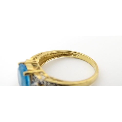 620 - A 9ct gold ring set with topaz flanked by diamonds. Ring size approx. O 1/2