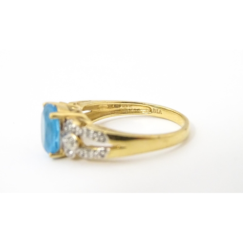 620 - A 9ct gold ring set with topaz flanked by diamonds. Ring size approx. O 1/2