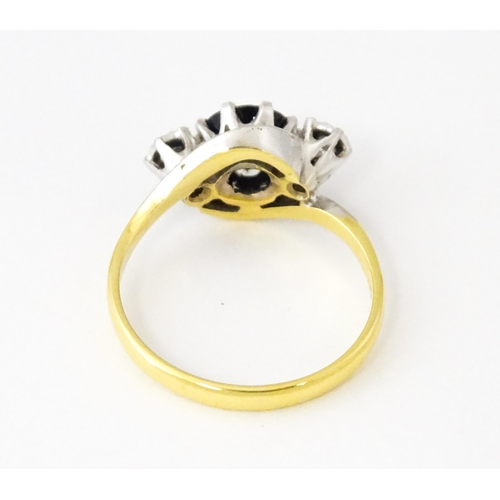 622 - An 18ct gold ring with platinum set central sapphire flanked by diamonds. Ring size approx. N