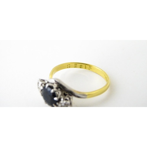 622 - An 18ct gold ring with platinum set central sapphire flanked by diamonds. Ring size approx. N