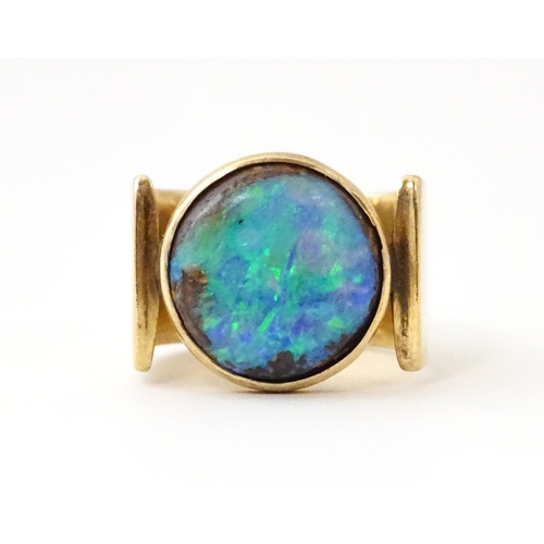 633 - An Arts & Crafts yellow metal ring set with opal cabochon. Ring size approx. H 1/2