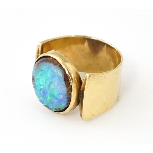 633 - An Arts & Crafts yellow metal ring set with opal cabochon. Ring size approx. H 1/2