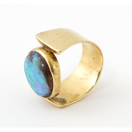 633 - An Arts & Crafts yellow metal ring set with opal cabochon. Ring size approx. H 1/2