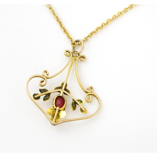 639 - An Art Nouveau yellow metal necklace, the pendant set with red stone detail. Pendant approx. 1 1/4