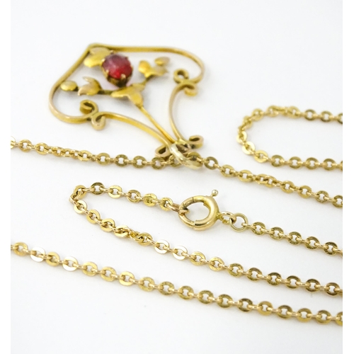 639 - An Art Nouveau yellow metal necklace, the pendant set with red stone detail. Pendant approx. 1 1/4