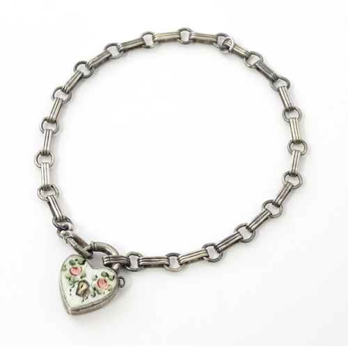 641 - A silver chain bracelet with padlock formed clasp having guilloche enamel and floral detail. Approx.... 