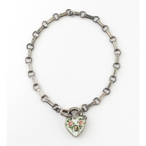 641 - A silver chain bracelet with padlock formed clasp having guilloche enamel and floral detail. Approx.... 