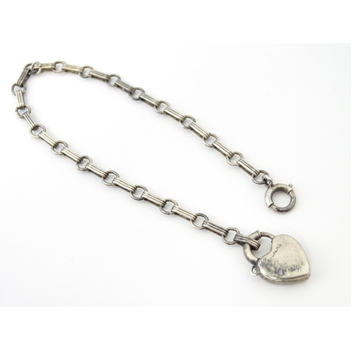 641 - A silver chain bracelet with padlock formed clasp having guilloche enamel and floral detail. Approx.... 