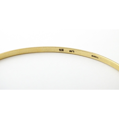 645 - A 9ct gold bracelet of bangle form with engraved decoration. Approx. 2 3/4