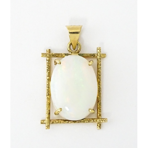 650 - A 9ct gold and yellow metal pendant set with central opal cabochon. Approx. 3/4