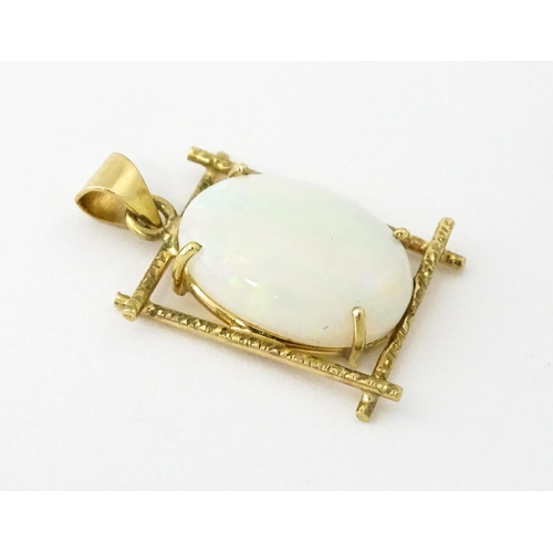 650 - A 9ct gold and yellow metal pendant set with central opal cabochon. Approx. 3/4