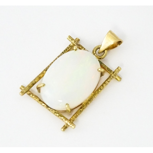 650 - A 9ct gold and yellow metal pendant set with central opal cabochon. Approx. 3/4