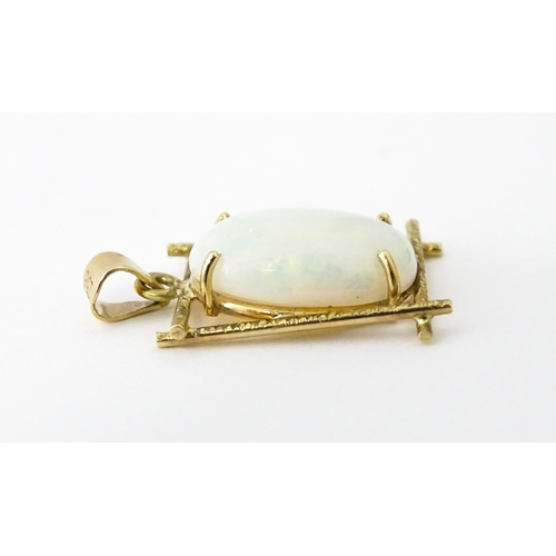 650 - A 9ct gold and yellow metal pendant set with central opal cabochon. Approx. 3/4