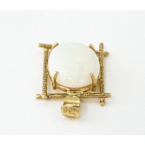 650 - A 9ct gold and yellow metal pendant set with central opal cabochon. Approx. 3/4