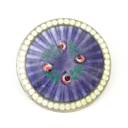 652 - A silver brooch of circular form with purple guilloche enamel decoration and floral detail, hallmark... 