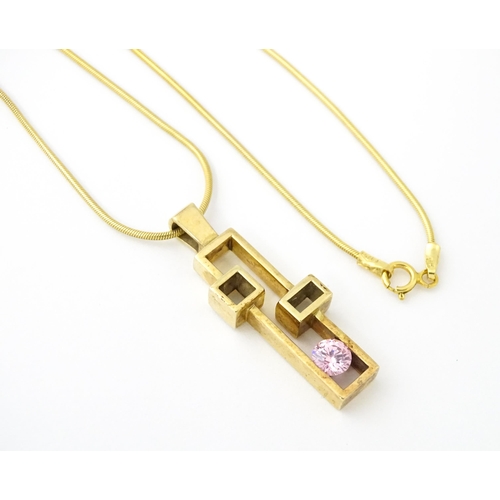 653 - A 9ct gold pendant on chain, the Modernist pendant set with pink stone, by Carrick Jewellery Ltd. Pe... 